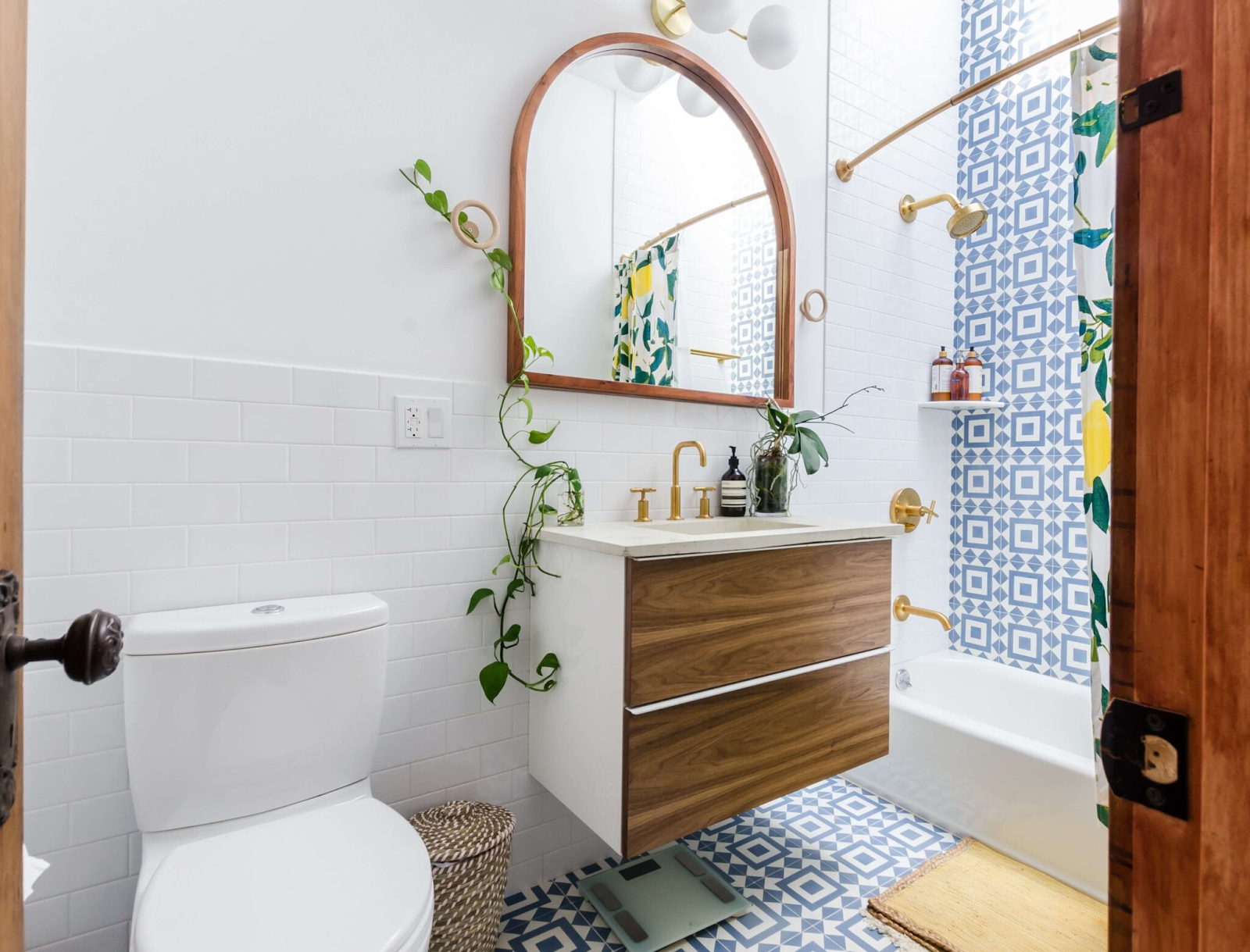 Modern bathroom with stylish tiles, a mirror, and a wooden cabinet.